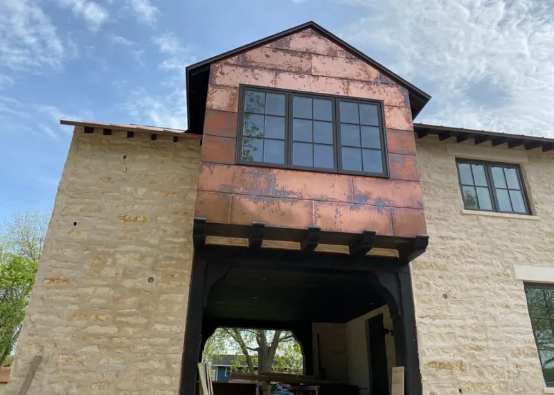 Copper metal panel facade on a stone building for Roof Repair in Riverview